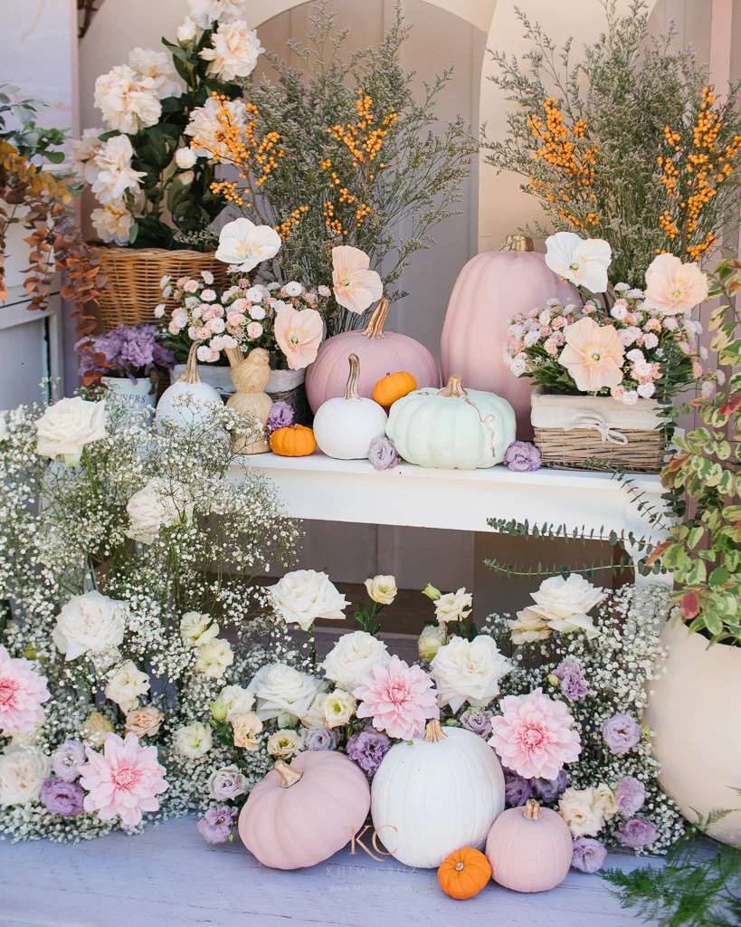 dainty pumpkin themed birthday setup with flowers and props by Khim Cruz