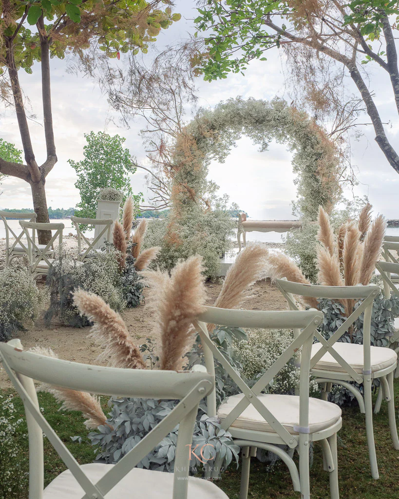 Boho wedding ceremony by the beach of Neil and Mieko with Gypsophila arch and aisle path by Khim Cruz