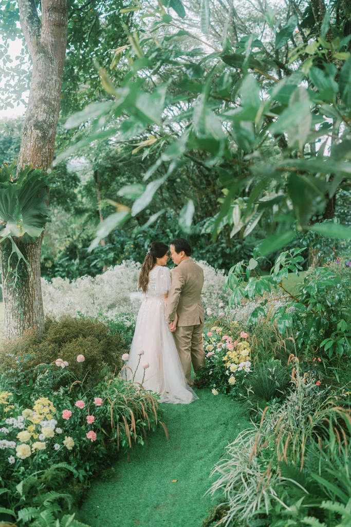 an outdoor 10th wedding anniversary renewal of vows ceremony with couple Pher and Iah on pathway under the tree event design by Khim Cruz