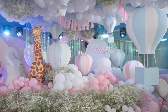 pastel safari hot air balloon stage design with giraffe and elephant props for girl and boy birthday party