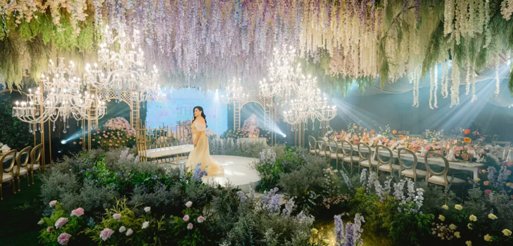 the celebrant on her 50th birthday standing in the middle of the ballroom with a French garden design by Khim Cruz