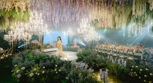 the celebrant on her 50th birthday standing in the middle of the ballroom with a French garden design by Khim Cruz