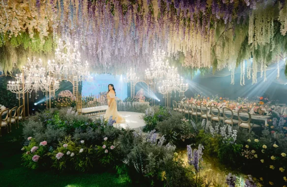 the celebrant on her 50th birthday standing in the middle of the ballroom with a French garden design by Khim Cruz