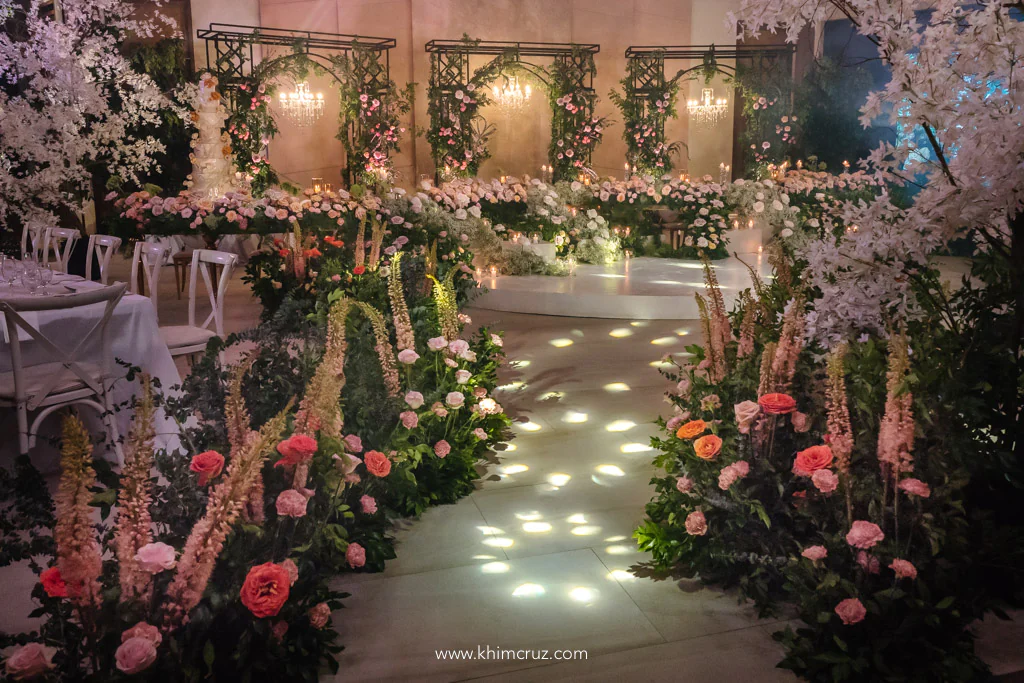elegant garden-feel wedding reception of Uzziel and Patricia entrance pathway leading towards head table with floral arches on the background