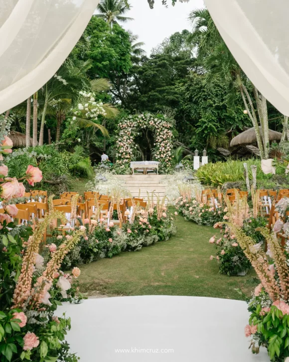 outdoor dreamy wedding ceremony of Uzziel and Patricia with floral pathway and arch by Khim Cruz