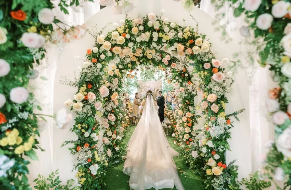 light and fresh-feel Tuscan wedding ceremony as the bride enters the wedding reception framed by floral arches