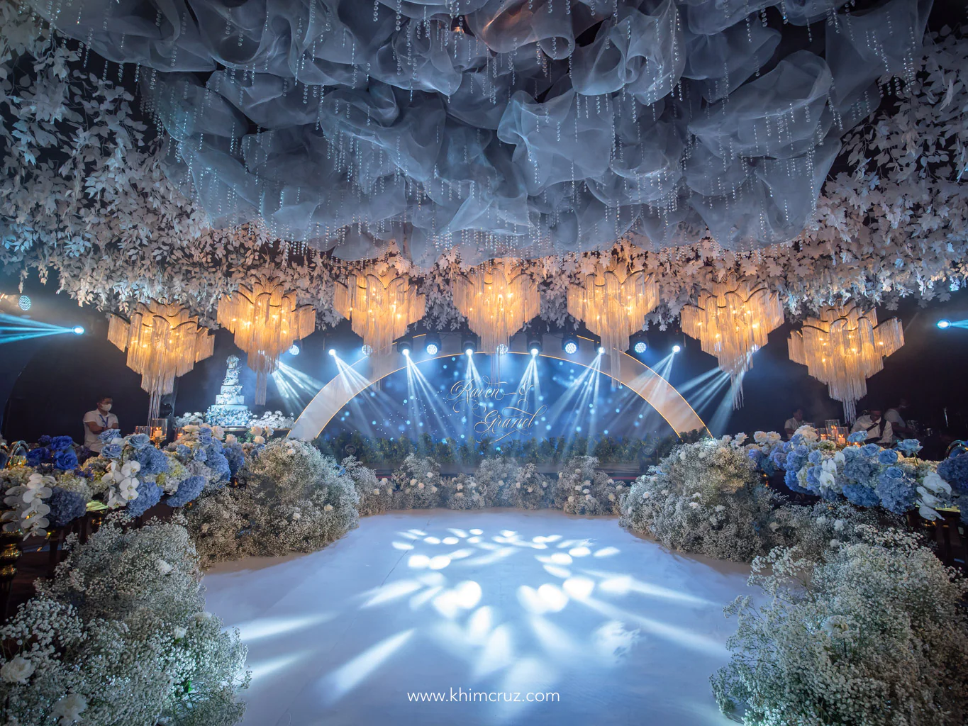 cloud ceiling installation above floral arrangements enclosing the dance floor with hanging chandeliers for a dreamy blue ethereal wedding designed by Khim Cruz