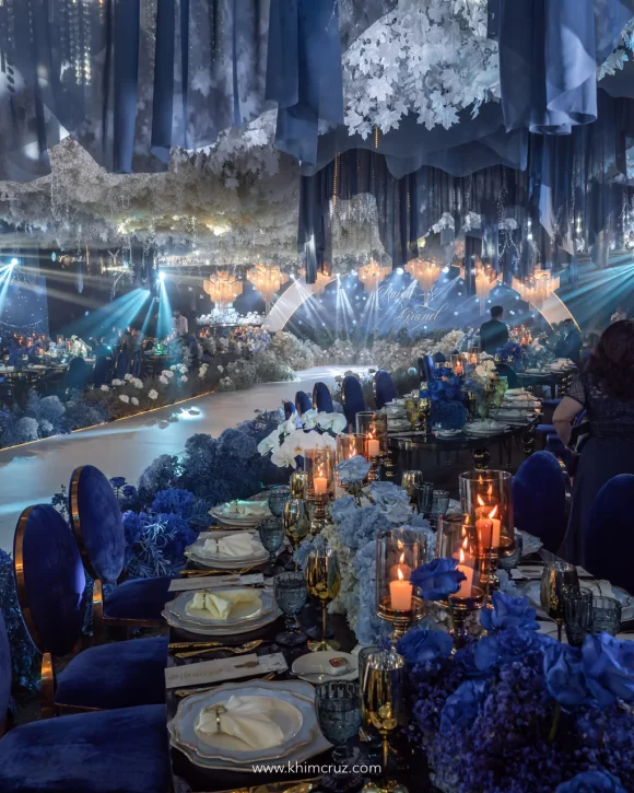 dreamy blue ethereal wedding gradient fabric shaped to mimic aurora borealis above table floral centerpieces with candles by Khim Cruz