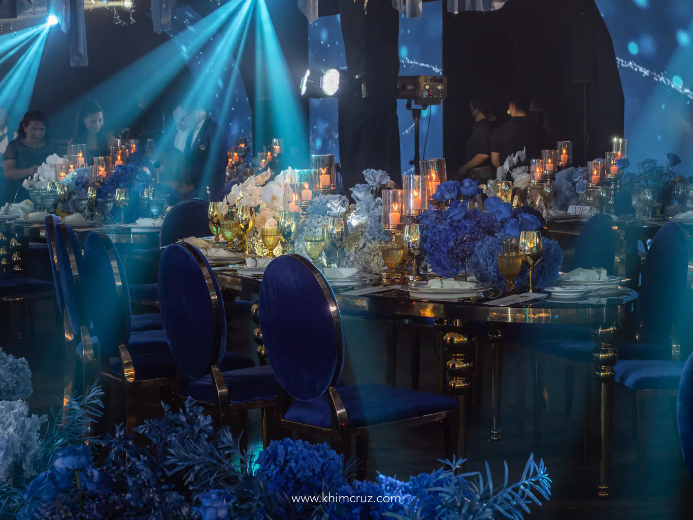 roses and phalaenopsis table centerpieces for a dreamy blue ethereal wedding behind are curved LED walls