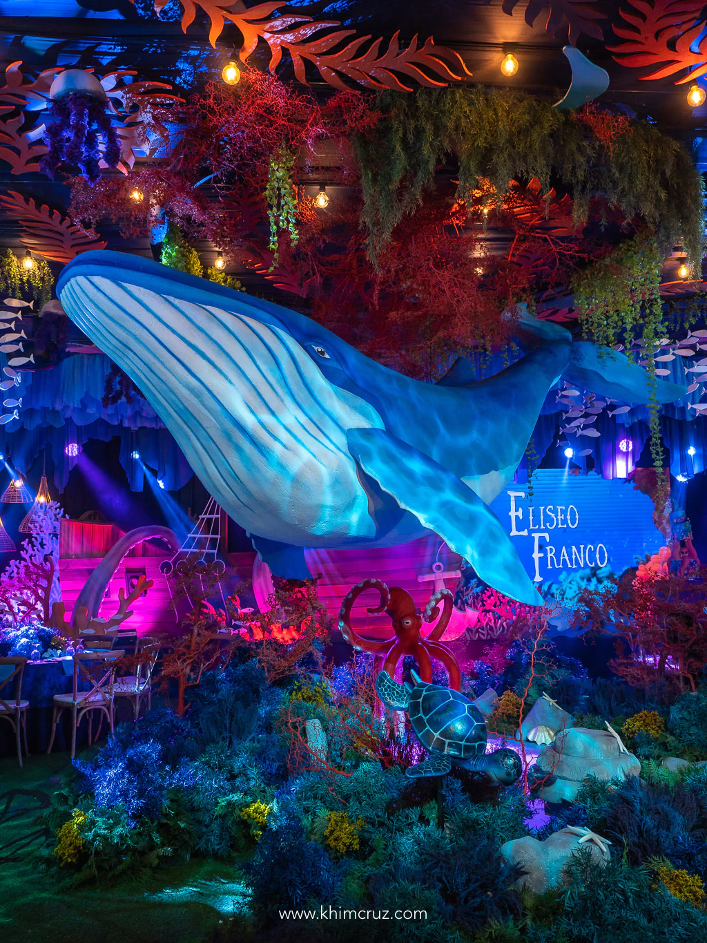massive whale swims above the rich coral reef on centerstage at under the sea birthday party by Khim Cruz