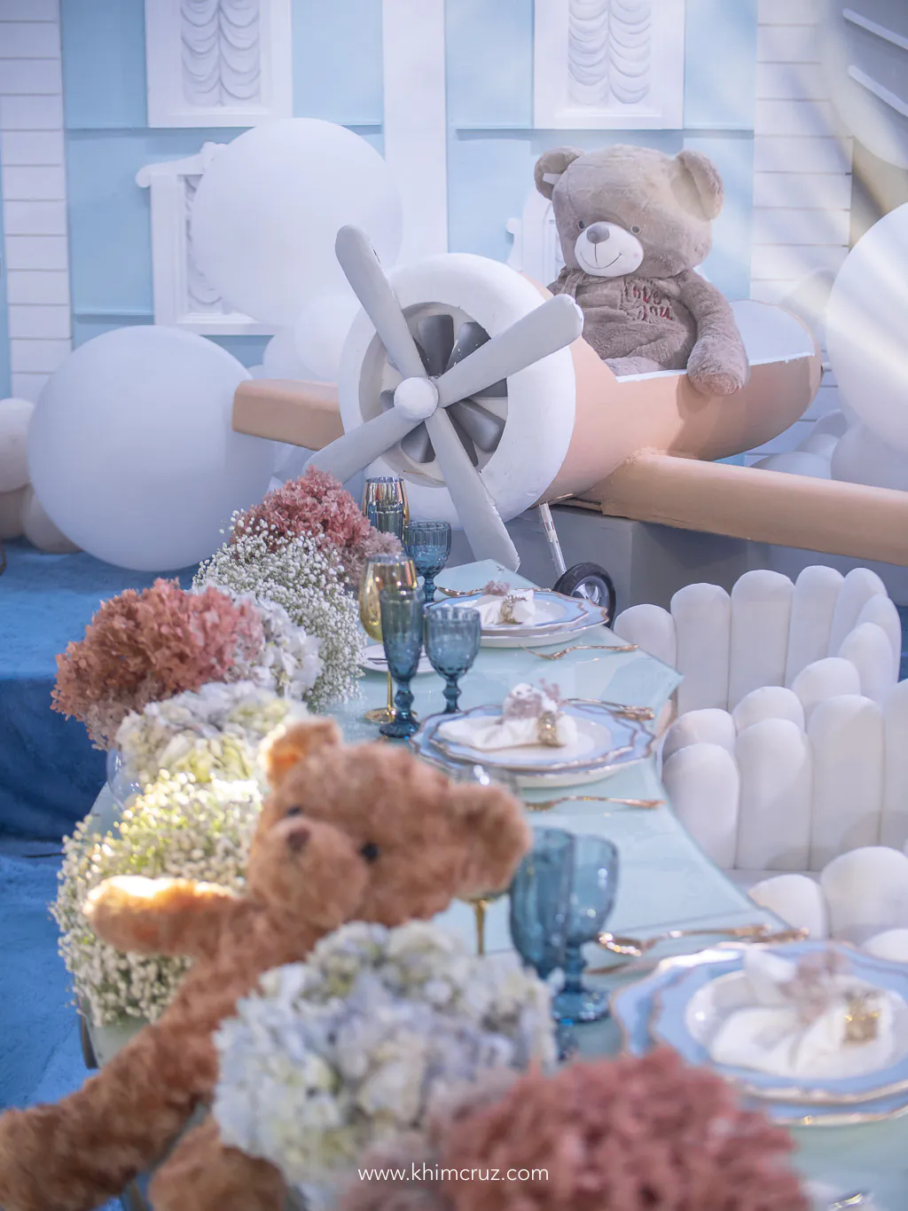 bear on toy plane at the end of head table with florals arranged by Khim Cruz