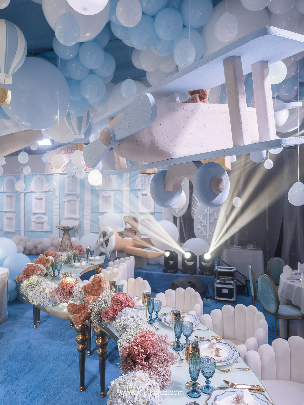 hanging toy plane and balloons over tables with florals