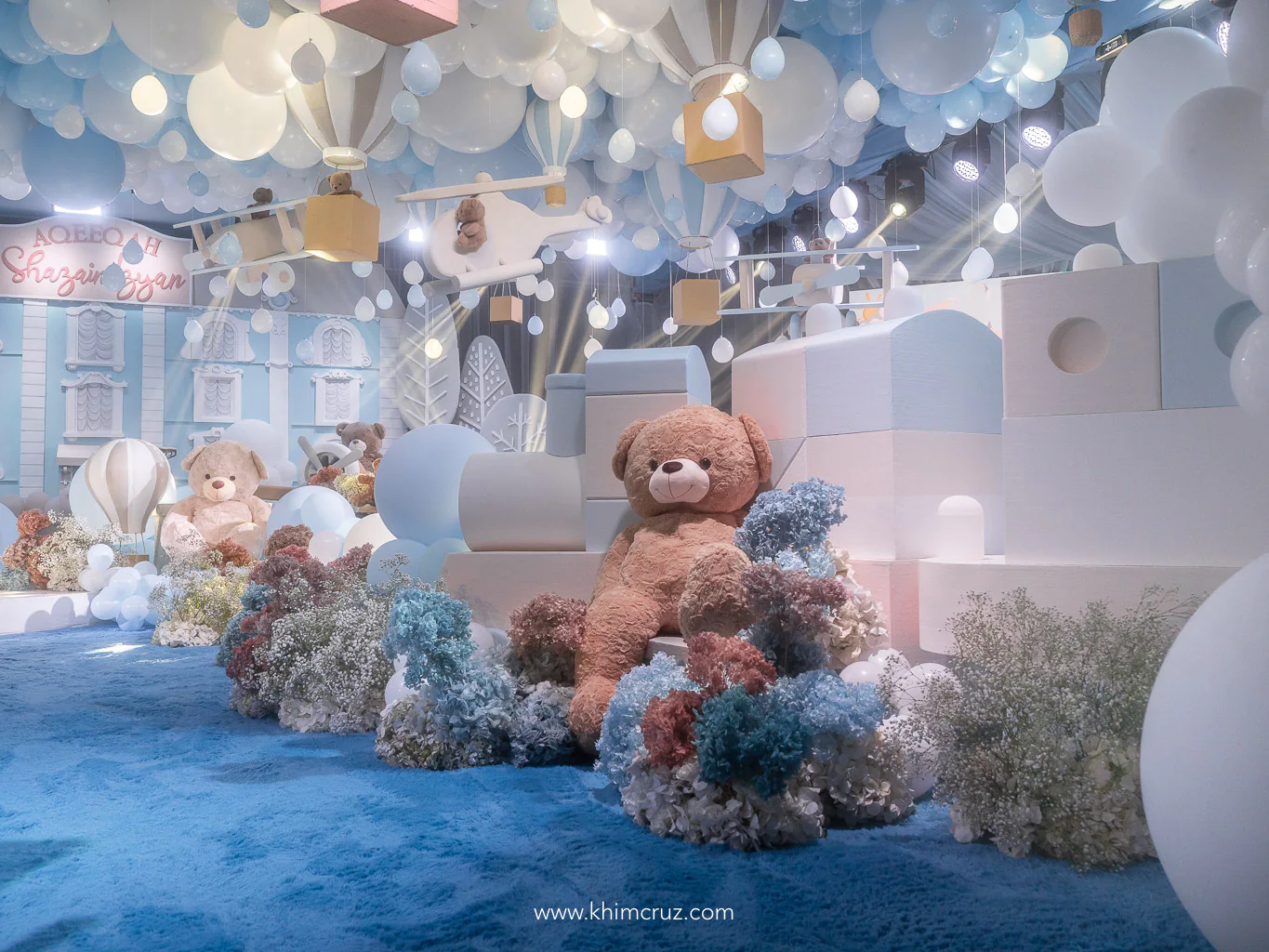 teddy bear leaning on toy train for a toy land themed boys party by Khim Cruz