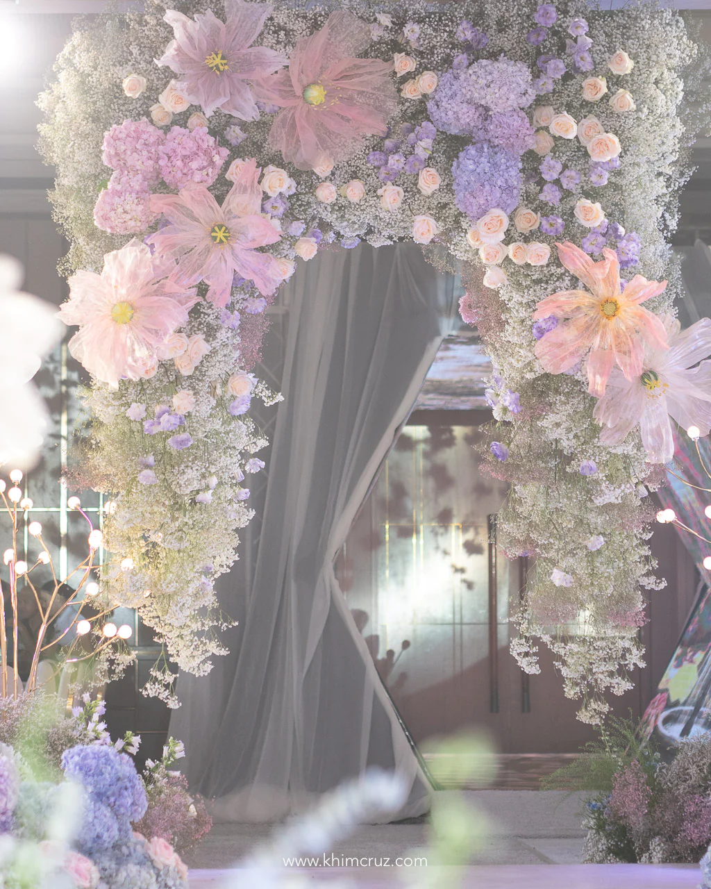 a beautiful dreamy hanging floral arch designed by Khim Cruz for a garden themed wedding reception