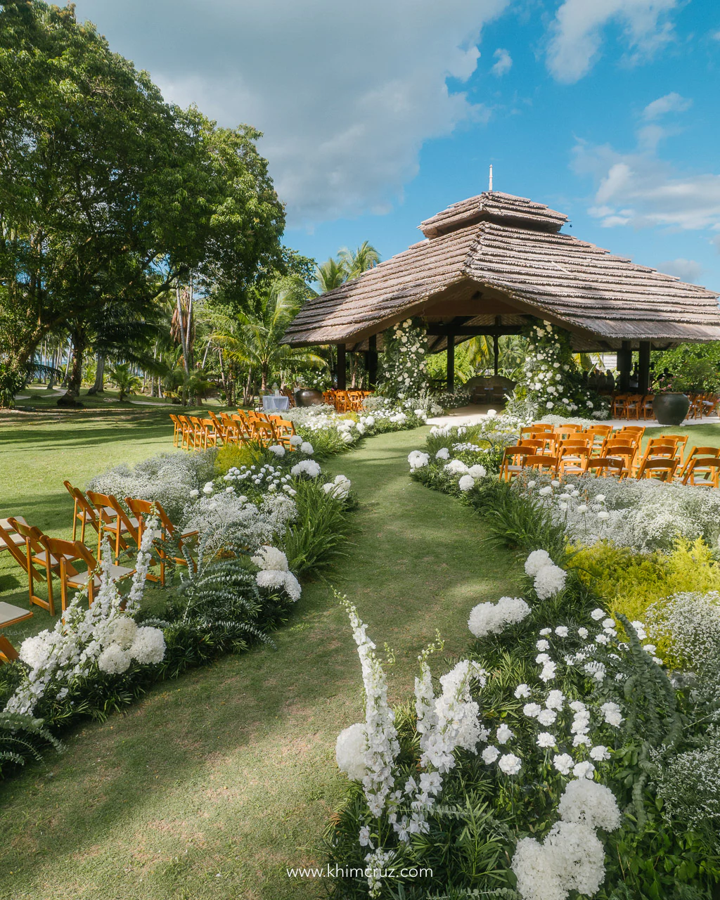Malipano island wedding ceremony amidst a picturesque field adorned with flowers by Khim Cruz
