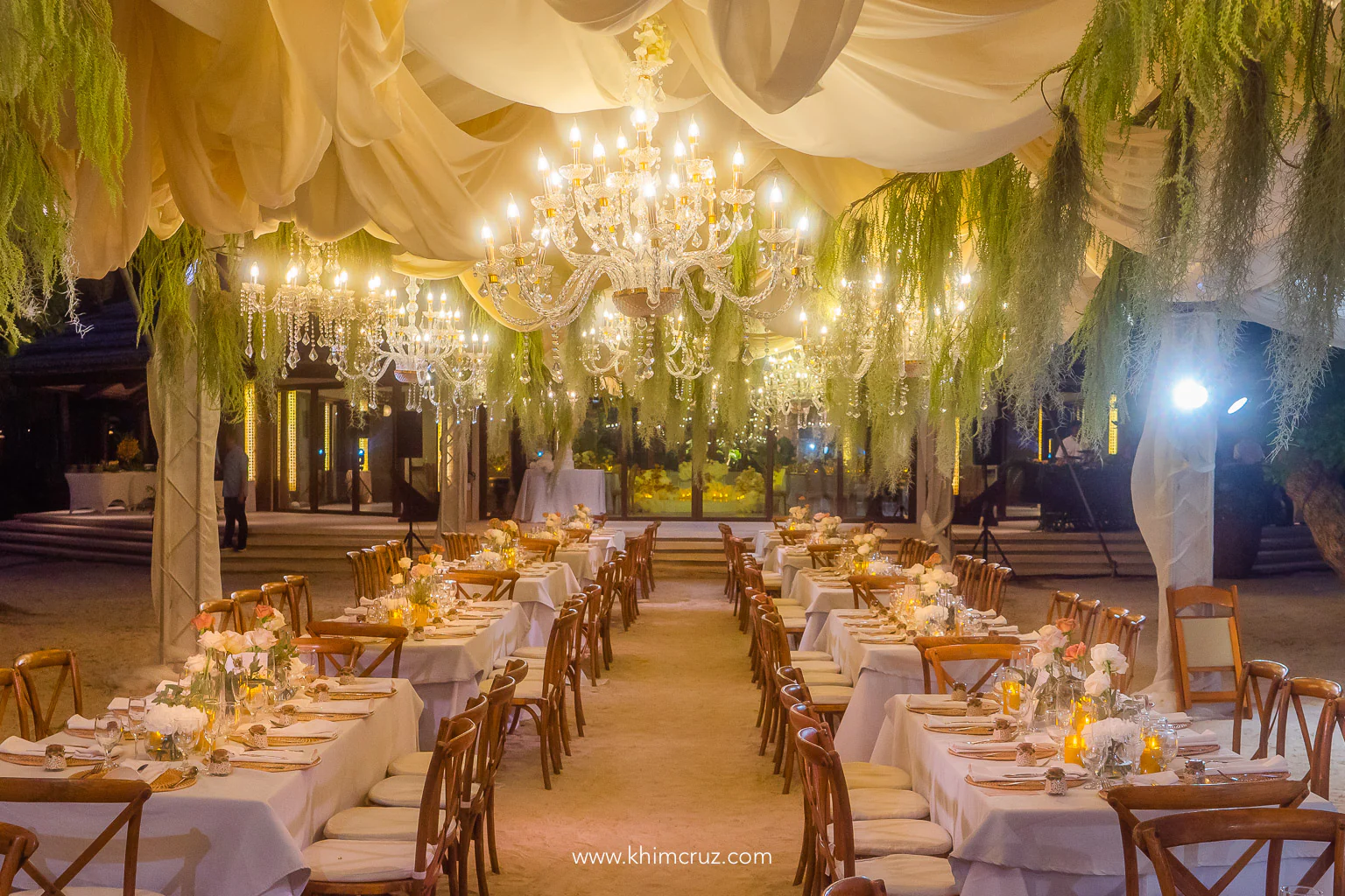 hanging chandeliers and drapes over beach wedding reception