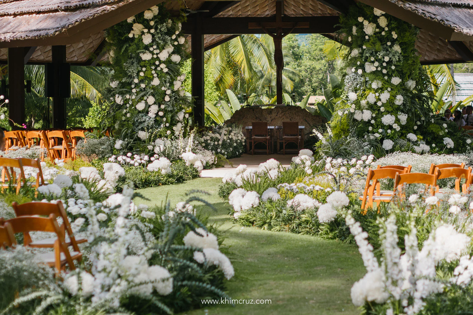 pillar florals standing to welcome the bride for this outdoor destination wedding ceremony