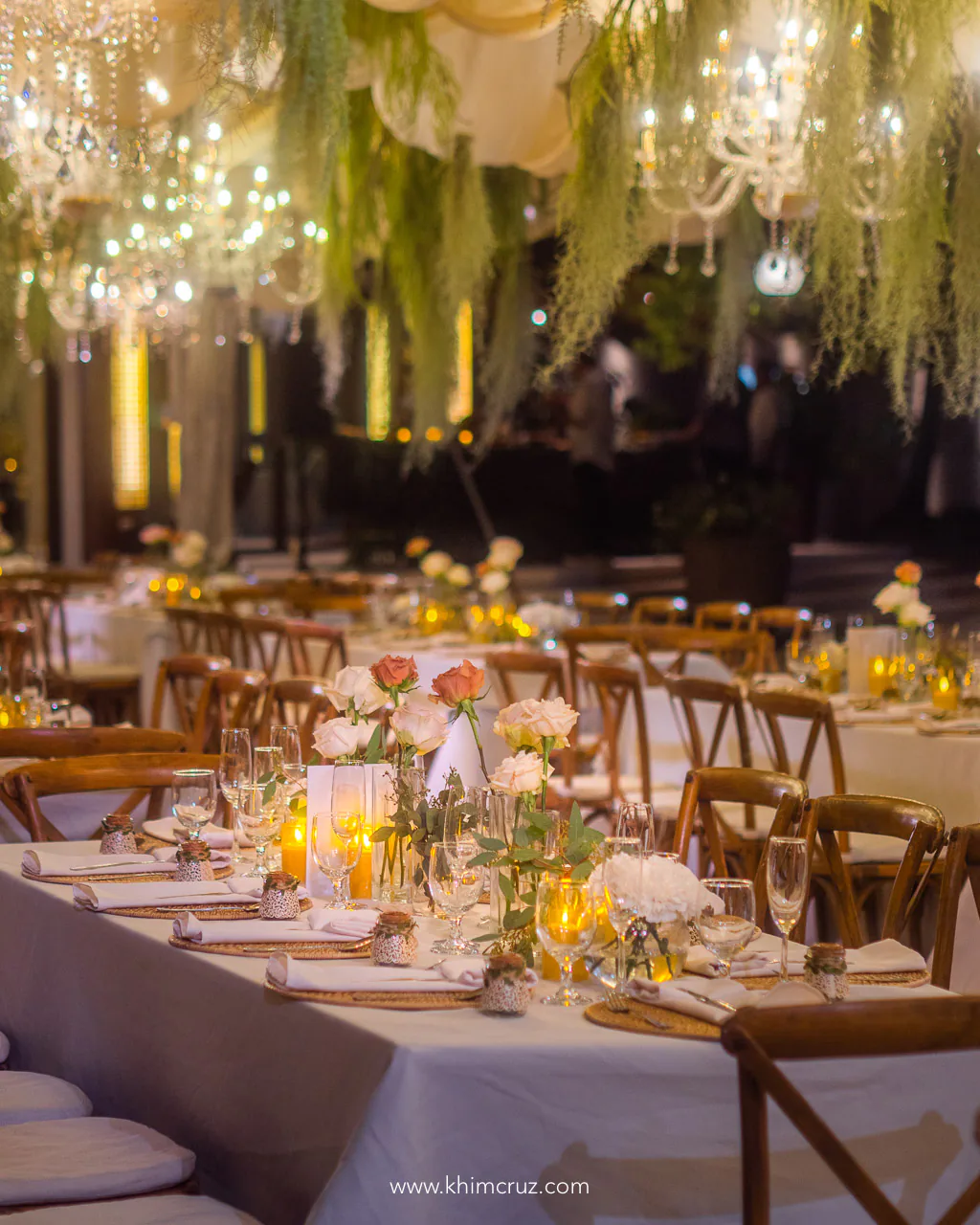 wedding reception along the beach with hanging chandeliers and drapes
