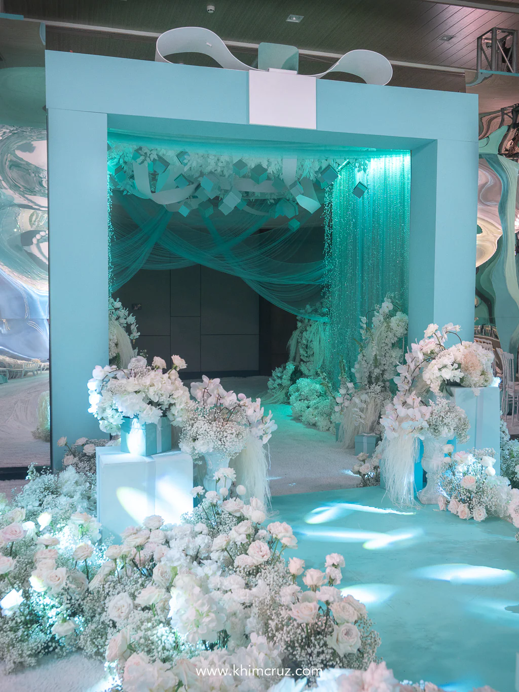 a grand box installation adorned with cascading crystals on walls to mimic falling diamonds and boxes on top at the entrance of this Tiffany-inspired wedding reception