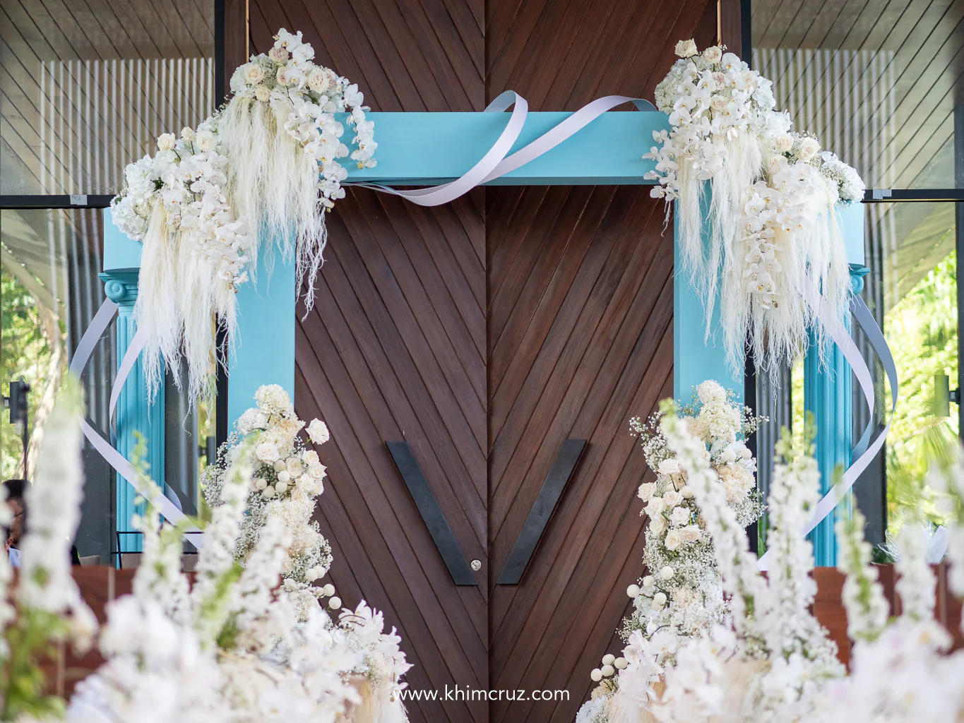 iconic blue arch wrapped in white ribbon with white floral design