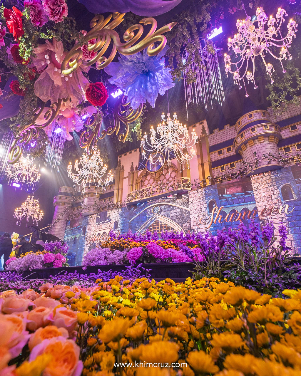 massive 20-foot Cinderella castle standing tall with colorful flower bed on the foreground