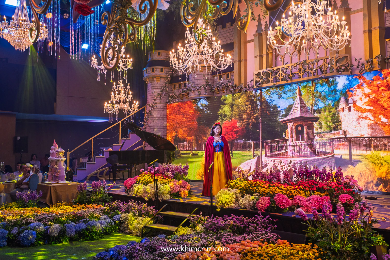 snow white performances against a princess castle and LED screen with colorful floral bed for a Disney princess-themed celebration