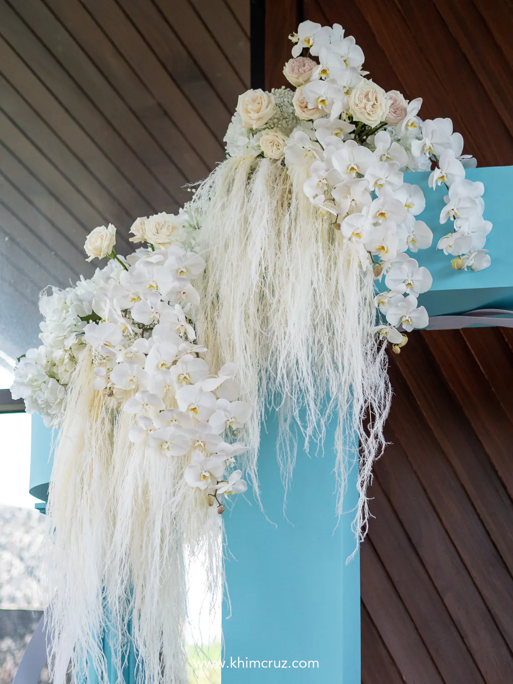 white florals arrangement details on top of iconic blue box arch