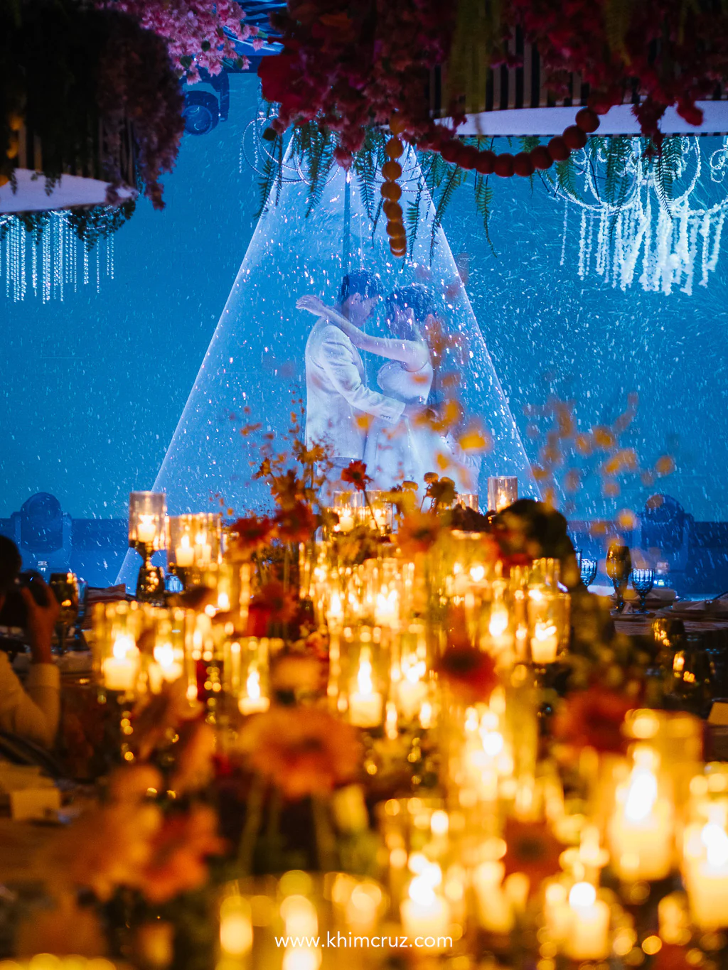 Bride and groom dancing through laser lights with candlelight flickering like their love