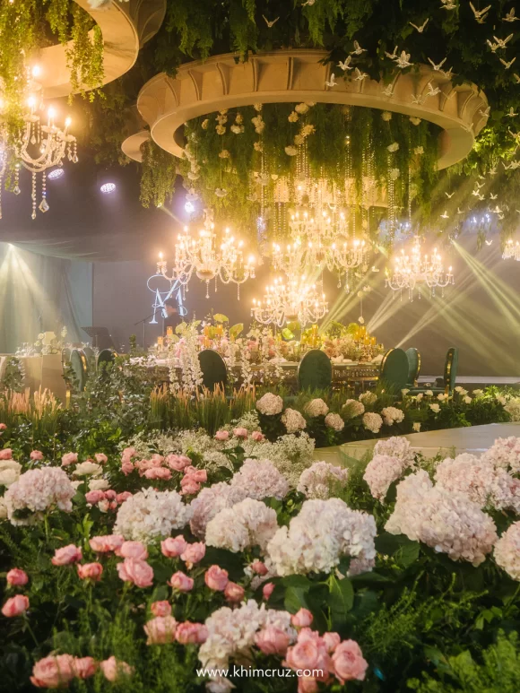 The wedding reception walkway is a lush garden scene, rich in texture and greenery styled by Khim Cruz