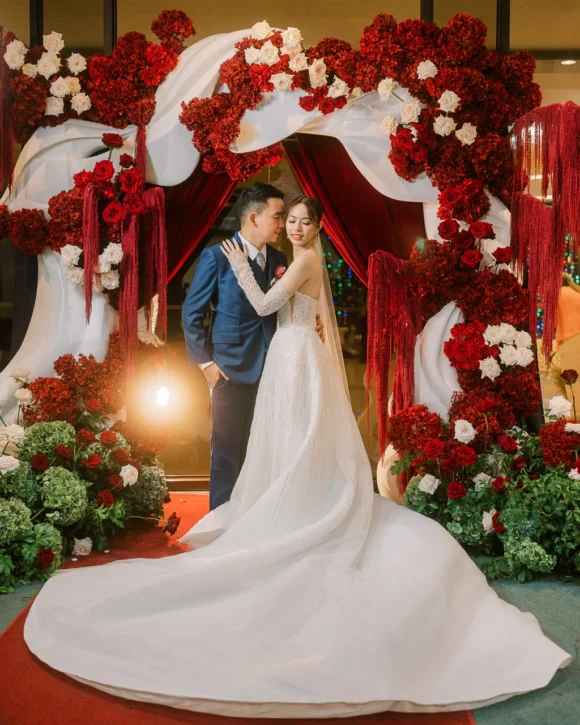 red-white-floral-arch-wave-backdrop-couple-wedding-ceremony